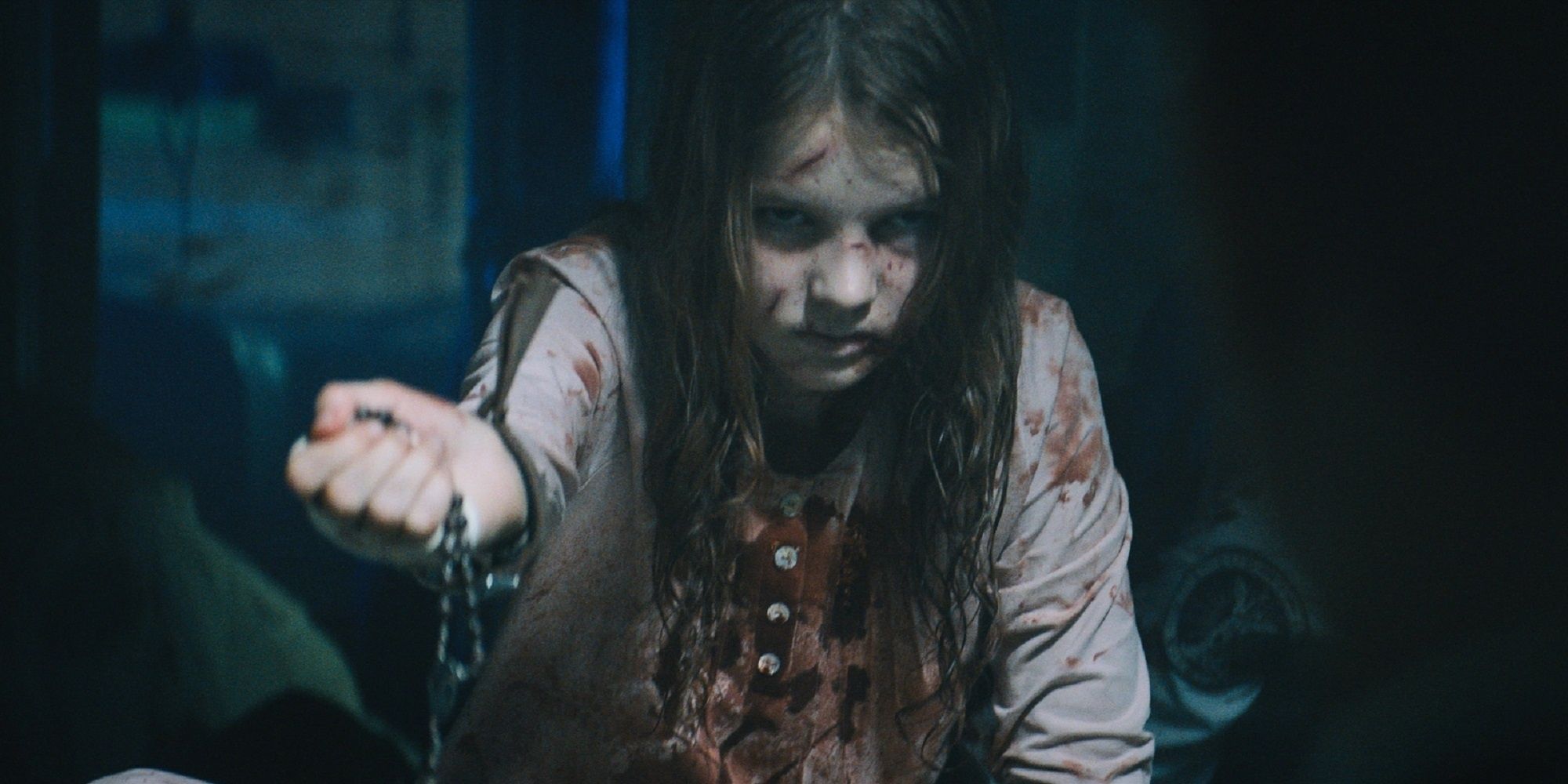 Een klein meisje bebloed en gekneusd met een rozenkrans in 'Prey for the Devil'.