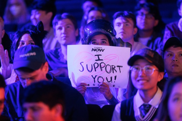 LCS-fan houdt "I Support You"-bord vast in de menigte bij Riot Games Arena.